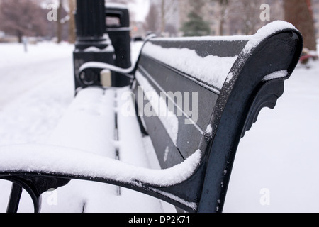 Den letzten Schneefall umfasst Bäume, Parkbänke und Trinkbrunnen im Victoria Park. Stockfoto