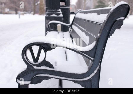 Den letzten Schneefall umfasst Bäume, Parkbänke und Trinkbrunnen im Victoria Park. Stockfoto