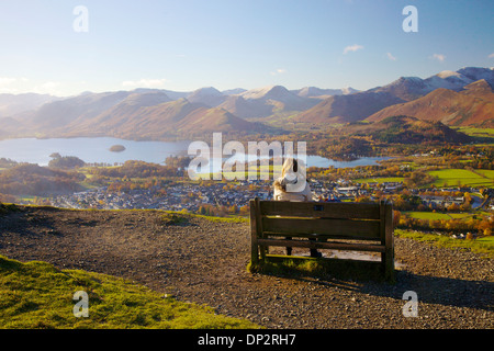 Weibliche Wanderer sitzen auf einer Bank in der Ansicht über Derwent Water in the Lake District National Park, UK Stockfoto