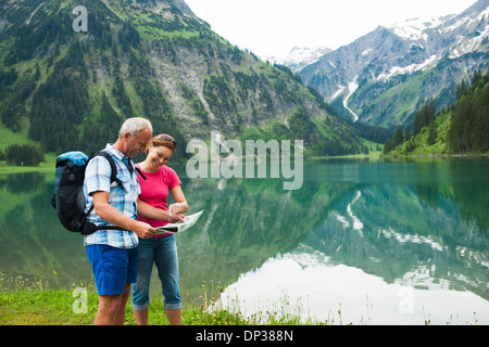 Älteres paar Blick auf Karte, Wandern in Bergen, See Vilsalpsee Tannheimer Tal, Österreich Stockfoto