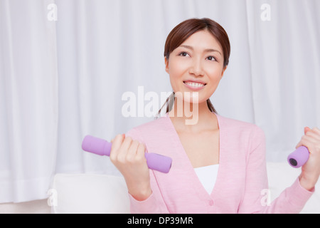 Junge Frau mit Hantel Stockfoto