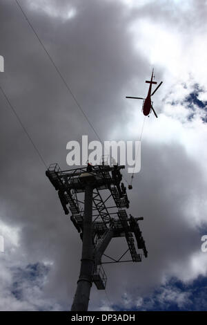 La Paz, Bolivien. 7. Januar 2014. Ein AS 350 B3 Ecureuil Helikopter trägt ein synthetisches Lichtkabel zwischen den Pylonen, der erste Teil des Prozesses der endgültigen Stahlseil zu installieren, die die Gondeln für die neue Seilbahn führt / Gondelbahn im Bau, die Städte La Paz und El Alto zu verknüpfen. Drei separate Seilbahn, die Linien sind geplant als Teil eines ehrgeizigen Projekts, Verkehrsstaus, mit der ersten Zeile aufgrund zu lindern bis März 2014 abgeschlossen sein. Das System wird von der österreichischen Firma Doppelmayr zu einem Preis von $ 234,6 Millionen von der bolivianischen Regierung finanzierten gebaut. Stockfoto