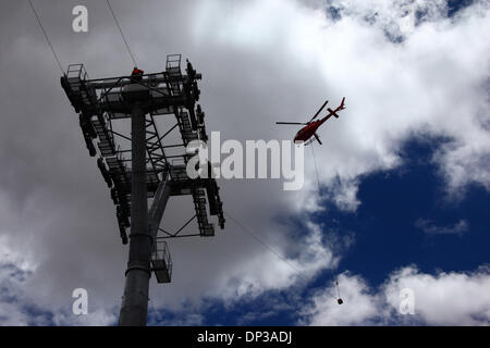 La Paz, Bolivien. 7. Januar 2014. Ein AS 350 B3 Ecureuil Helikopter trägt ein synthetisches Lichtkabel zwischen den Pylonen, der erste Teil des Prozesses der endgültigen Stahlseil zu installieren, die die Gondeln für die neue Seilbahn führt / Gondelbahn, die derzeit im Bau, die Städte La Paz und El Alto zu verknüpfen. Drei Kabel Auto Linien sind geplant als Teil eines ehrgeizigen Projekts, Verkehrsstaus, mit der ersten Zeile aufgrund zu lindern bis März 2014 abgeschlossen sein. Das System wird von der österreichischen Firma Doppelmayr zu einem Preis von $ 234,6 Millionen von der bolivianischen Regierung finanzierten gebaut. Stockfoto