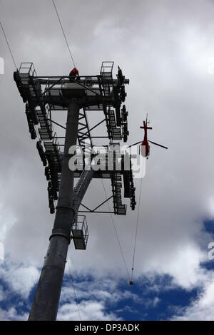 La Paz, Bolivien. 7. Januar 2014. Ein AS 350 B3 Ecureuil Helikopter trägt ein synthetisches Lichtkabel zwischen den Pylonen, der erste Teil des Prozesses der endgültigen Stahlseil zu installieren, die die Gondeln für die neue Seilbahn führt / Gondelbahn, die derzeit im Bau, die Städte La Paz und El Alto zu verknüpfen. Drei Kabel Auto Linien sind geplant als Teil eines ehrgeizigen Projekts, Verkehrsstaus, mit der ersten Zeile aufgrund zu lindern bis März 2014 abgeschlossen sein. Das System wird von der österreichischen Firma Doppelmayr zu einem Preis von $ 234,6 Millionen von der bolivianischen Regierung finanzierten gebaut. Stockfoto