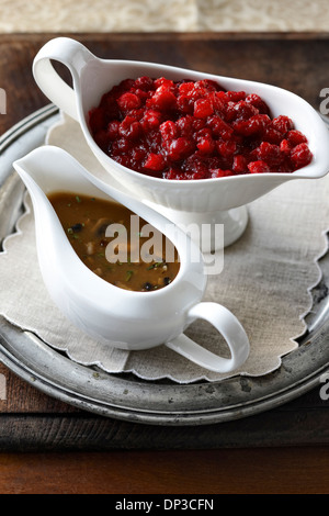 Zwei Soße Boote für Thanksgiving Essen, Studioaufnahme mit Pilz-Soße und Preiselbeeren gefüllt. Stockfoto