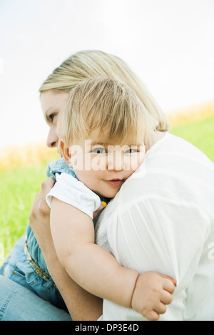 Mutter umarmt Baby Tochter im Freien, Mannheim, Baden-Württemberg, Deutschland Stockfoto