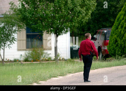 6. Juli 2006; Kerrville, TX, USA; Ein Gesetz Offizier geht die Straße der Nachbarschaft am Highway 16 Kathy in Kerr County, wo ein Kind ihr älteren Bruder gefunden, und Mutter tot in ihrem Haus am Mittwoch, 5. Juli 2006. Obligatorische Credit: Foto von Billy Calzada/San Antonio Express-News/ZUMA Press. (©) Copyright 2006 von San Antonio Express-News Stockfoto