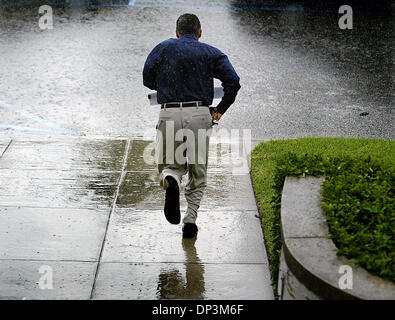 12. Juli 2006; West Palm Beach, FL, USA; Eine tropische Welle, die von den Bahamas Einzug links viele Teile der Grafschaft gesättigt. Picured: Wie Regen strömte nach unten Wedsnesday Morgen in West Palm Beach, ein Mann-Sprints unten die Schritte des Palm Beach County Health Department Gebäudes und versucht es zu seinem Auto zu machen, bevor Sie immer völlig durchnässt.    Obligatorische Credit: Foto von Damon Hallo Stockfoto