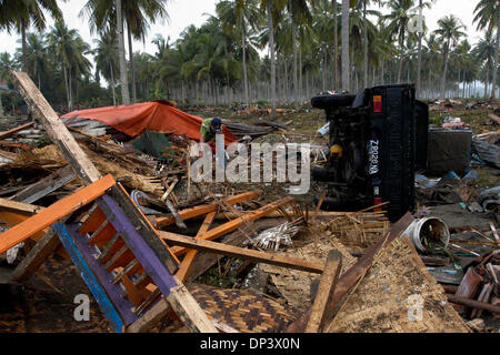 19. Juli 2006; Ciamis, West-Java, Indonesien; Indonesische Tsunami-Überlebende Ade Kusmawan sammelt benutzbare Gegenstände aus seinem Haus sowie bereinigt sein beschädigtes Auto das von Montages Tsunami in Pangandaran Strandbereich mitgerissen. Ein Tsunami traf die Küste der indonesischen Insel Java und hat mehr als 550 Leben, verlassen über 600 verletzt, rund 38.000 anderen wurden durch vertrieben Stockfoto