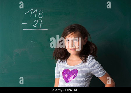 Porträt von Mädchen steht vor Tafel im Klassenzimmer, Deutschland Stockfoto