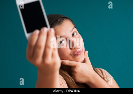 Mädchen unter Bild von sich selbst mit Smartphone, Deutschland Stockfoto