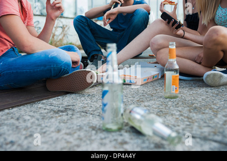 Oberflächenansicht Ebene der Gruppe von Jugendlichen sitzen am Boden im Freien, Pizza essen und rumhängen, Deutschland Stockfoto
