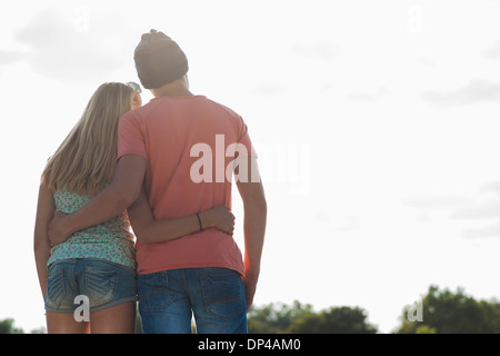 Rückansicht des Teenager-Jungen und Teenager-Mädchen mit Arme umeinander, stehen im Freien, Deutschland Stockfoto