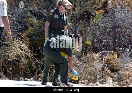 5. August 2006; San Bernardino, Kalifornien, USA; Detektive mit dem San Bernardino county Sheriff Department untersuchen die menschliche Überreste gefunden entlang Cajon Blvd. in der Nähe von San Bernardino, Kalifornien, auf Samstag, 5. August 2006.  Der Körper wird geglaubt, um Charles Ray Hedlund zu sein, die vor drei Tagen vermisst gemeldet wurde.  Der Verdächtige, John Wayne Thompson, wurde mit der Ermordung von Charles He angeklagt Stockfoto