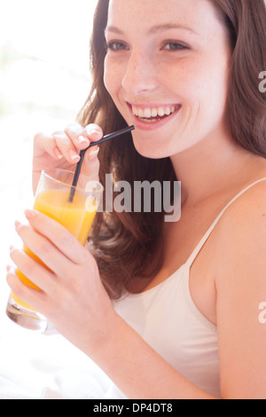 Junge Frau trinken Fruchtsaft Stockfoto