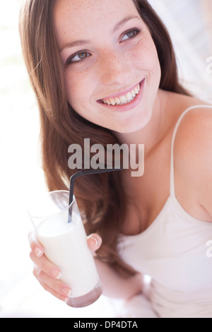 Junge Frau trinkt Milch Stockfoto