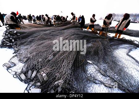 Zhaodong, Chinas Provinz Heilongjiang. 7. Januar 2014. Fischer überprüfen Sie das Netz auf den eisbedeckten Fluss Songhua River in Zhaodong City, Nordost-China Provinz Heilongjiang, 7. Januar 2014. Der Winter Angeln begann bei kühlem Wetter mit 30 Grad Celsius unter dem Gefrierpunkt. Bildnachweis: Wang Kai/Xinhua/Alamy Live-Nachrichten Stockfoto