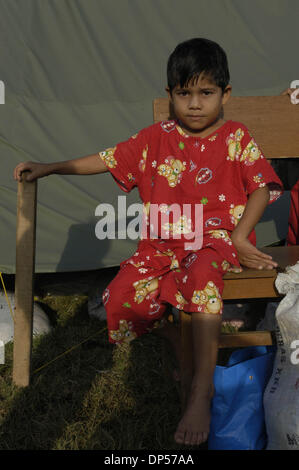 Sep 06, 2006; Banda Aceh, Indonesien; Molidiye, sechs jährigen Flüchtling sitzt vor einem Zelt Gue Gajah Hütten Camp. Ihre Familie überlebt haben, wie sie auf den Berg gestiegen, wenn ihr Haus im Pulo Aceh Village, zwei Stunden mit dem Schiff von Banda Aceh Tsunami in. Sie blieben fünf Tage auf der Insel dann gerettet, die Hütten-Camp. Nach Wardiyah, ihre Tante, sie weinte, als sie Stockfoto
