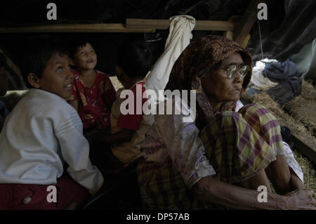 Sep 06, 2006; Banda Aceh, Indonesien; Was Muhammad (weißes Hemd) spielt mit seiner jüngeren Schwester Molidiye (rotes Tuch) als ihre Urgroßmutter Tagträumen in einem Zelt im Gue Gajah Hütten Camp. Ihre Familie überlebt haben, wie sie auf den Berg gestiegen, wenn ihr Haus im Pulo Aceh Village, zwei Stunden mit dem Schiff von Banda Aceh Tsunami in. Sie waren für fünf Tage auf der Insel dann retten Stockfoto