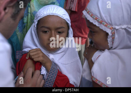 Sep 06, 2006; Banda Aceh, Indonesien; Eine Aceh Flüchtling Mädchen bekommt eine Meningitis Vaccins wie ihre Freundin, die gerade nach einer Notfall-Klasse an der indonesischen Staat Fernsehen (TVRI) Flüchtlingslager. Sie nahmen Flüchtling als am Sonntag Erdbeben mit anschließendem Tsunami-Flutwelle am 26. Dezember 2004 der Stadt, darunter Schulen betroffen.  Obligatorische Credit: Foto von Ng Swan Ti/JiwaFoto/ZUMA Press. ( Stockfoto