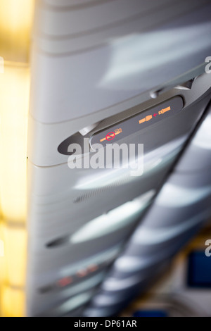 Nahaufnahme von der beleuchteten befestigen Sie Sicherheitsgurt und kein Rauchen Schilder in einem Flugzeug, selektiven Fokus auf Schildern. Stockfoto