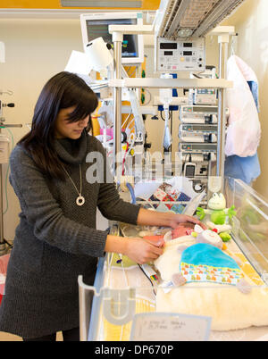 Braunschweig, Deutschland. 7. Januar 2014. Eine Mutter steht vor Inkubator in die ihr ihren vorzeitigen gelieferten Sohn Valentin liegt in einem Raum von der pädiatrischen Intensivstation des Klinikum Braunschweig in Braunschweig, Deutschland, 7. Januar 2014. Die Intensivstation für Kinder inzwischen existiert schon seit 35 Jahren und ist damit der älteste Intensivstation für Frühgeborene und Kinder in Niedersachsen. Foto: Jochen Luebke/Dpa/Alamy Live News Stockfoto