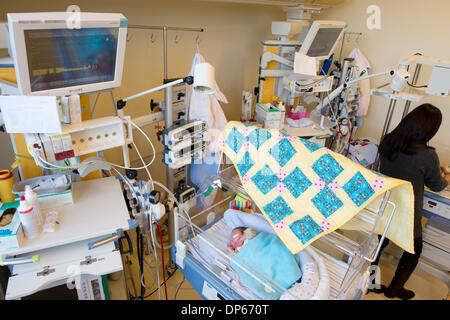 Braunschweig, Deutschland. 7. Januar 2014. Eine Mutter steht vor Inkubator in die ihr ihren vorzeitigen gelieferten Sohn Valentin liegt in einem Raum von der pädiatrischen Intensivstation des Klinikum Braunschweig in Braunschweig, Deutschland, 7. Januar 2014. Die Intensivstation für Kinder inzwischen existiert schon seit 35 Jahren und ist damit der älteste Intensivstation für Frühgeborene und Kinder in Niedersachsen. Foto: Jochen Luebke/Dpa/Alamy Live News Stockfoto