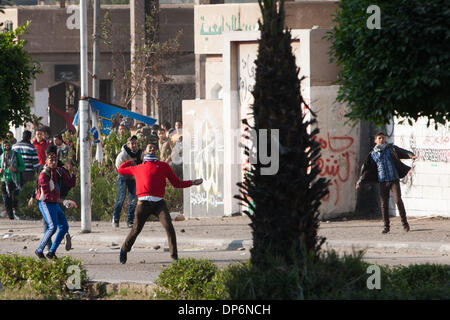 Kairo, Ägypten. 8. Januar 2014. Protestierende Studenten mit Steinen auf Polizisten vor der Azhar-Universität in Kairo, Ägypten, 8. Januar 2014 werfen. Kairo Strafgerichtshof vertagte am Mittwoch die Testversion des gestürzten Präsidenten Mohamed Morsi über Anstiftung zu töten Demonstranten zum 1. Februar wegen des schlechten Wetters, die seinen Transport des Gerichts verhindert das Staatsfernsehen berichtet. Bildnachweis: Cui Xinyu/Xinhua/Alamy Live-Nachrichten Stockfoto