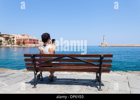 Junge Frau Fotografieren an der Bucht von Chania in Kreta, Griechenland Stockfoto