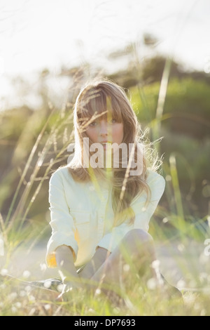 Blonde Hipster Mädchen sitzen auf dem Rasen, Blick in die Kamera Stockfoto