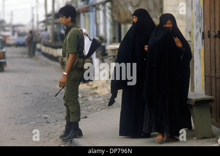Rafah, Palästinenser, Gazastreifen April 1982. Palästinensische Frau und israelischer Soldat an der neuen Kreuzung. Als sich Israel 1982 aus dem Sinai zurückzog, wurde Rafah in einen Gazanteil und einen ägyptischen Teil geteilt, der Familien trennte, die durch Stacheldrahtschranken getrennt waren. Der Kern der Stadt wurde von Israel und Ägypten zerstört, um eine große Pufferzone zu schaffen. 1980er Jahre HOMER SYKES Stockfoto