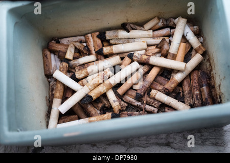 Rauchen - Zigarettenstummel in einem schmutzigen Aschenbecher im freien Stockfoto