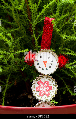 handgemachte Christbaumschmuck neben einer kleinen Tanne Stockfoto