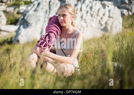 Frau mit Kletterausrüstung hockend nach unten Stockfoto