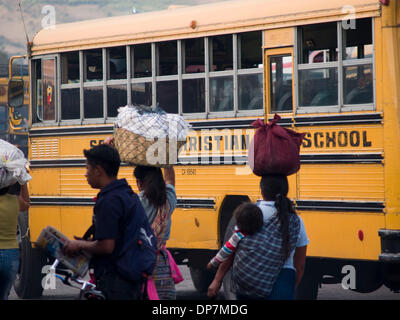 24. März 2006 - Antigua, Guatemala - Menschen in der Busbahnhof, wo ehemalige amerikanische Schulbusse jetzt als Guatemalas nah- und Fernverkehr Busse, teilweise mit alten Markierungen aus ihrem früheren Leben in Amerika, noch intakt ist dienen, kontrastieren mit der lokalen Kultur am Busbahnhof in der Stadt Antigua Guatemala (Credit-Bild: © David H. Wells/ZUMAPRESS.com) Stockfoto