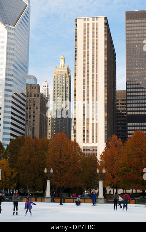 Menschen Sie Eislaufen im McCormick Tribut Plaza und Eisbahn mit Chicagos Skyline im Hintergrund. Stockfoto