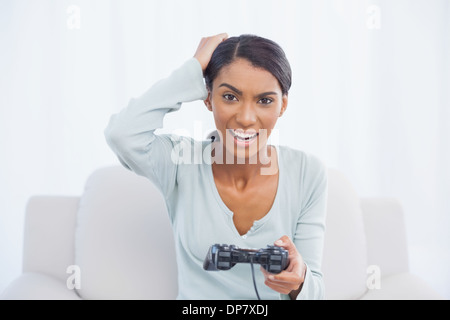 Irritiert Frau sitzt auf dem Sofa spielen von Videospielen Stockfoto