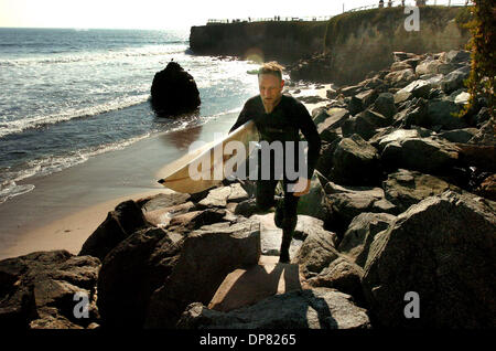 Sep 14, 2006 - Santa Cruz, CA, USA - Surfer CARY FREEMAN Spaziergänge entlang einige Küste Rüstung als verlässt er das Meer in Santa Cruz, Calif.The Rüstung des großen Felsbrocken liegen sporatically entlang der Küste von West Cliff Drive, wo Erosion der Gehweg und Fahrbahn gefährdet hat. Stockfoto