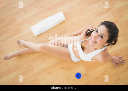 Fit glückliche Frau, die einen Anruf bei ihrem Training, Blick in die Kamera Stockfoto