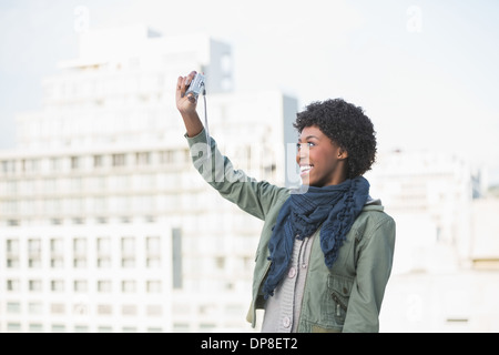 Fröhliche lässige Frau selbst fotografieren Stockfoto