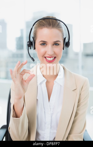 Lächelnden hübschen Callcenter-Agent geben okay Geste Stockfoto