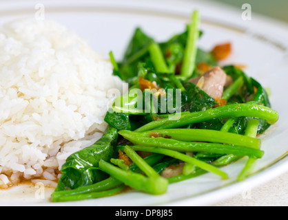 Chinesischer Brokkoli oder Chinesisch Grünkohl mit knusprigem Schweinefleisch neben Reis gebraten. Stockfoto