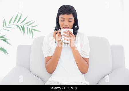 Natürliche schwarze behaarte Frau in weißen Kleidern Kaffeegenuss Stockfoto