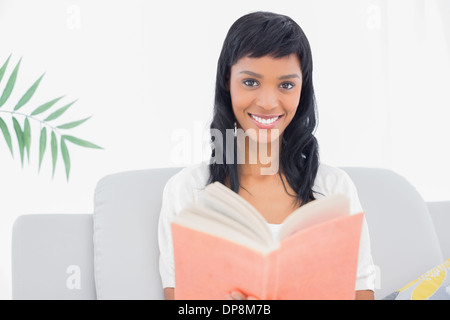 Schöne schwarze behaarte Frau in weißen Kleidern, ein Buch zu lesen Stockfoto