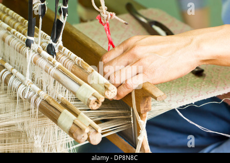 Schließen Sie aus Seide gewebt Maschine mit Hand. Stockfoto