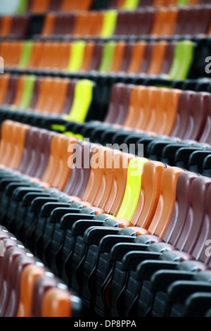 Leere Sitzreihen in verschiedenen Farben in einem Stadion Stockfoto