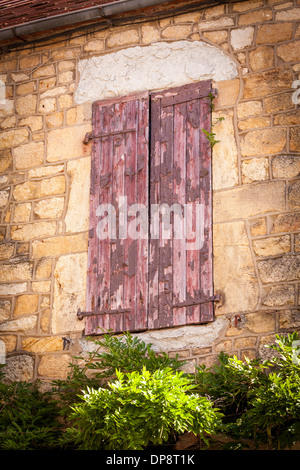 Domme, Dordogne, Frankreich, Europa. Alte Fenster mit hölzernen Fensterläden auf einer alten traditionellen Gebäude aus Stein. Stockfoto