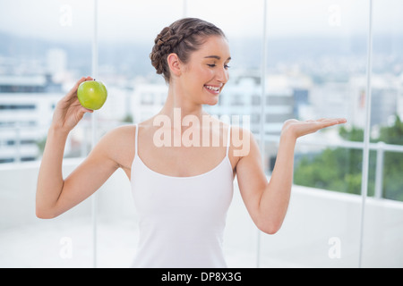 Glücklich sportliche Brünette mit grünem Apfel Stockfoto