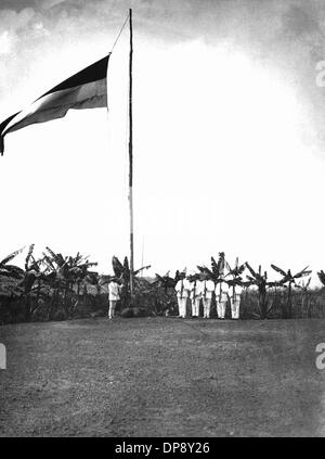 Männer in Anzügen tropischen Hissen einer Flagge auf einer Militärbasis in der deutschen Kolonie Kamerun (undatiertes Bild aus der Kolonialzeit). Kamerun war eine deutsche Kolonie von 1884 zum ersten Weltkrieg und wurde im Jahre 1916 zwischen Großbritannien und Frankreich aufgeteilt. Die unabhängige Republik Kamerun wurde am 1. Januar 1960 erklärt. Stockfoto