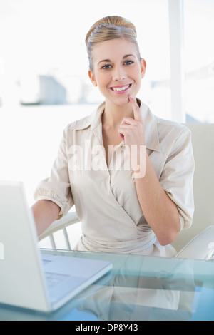 Fröhliche junge blonde Geschäftsfrau mit einem laptop Stockfoto